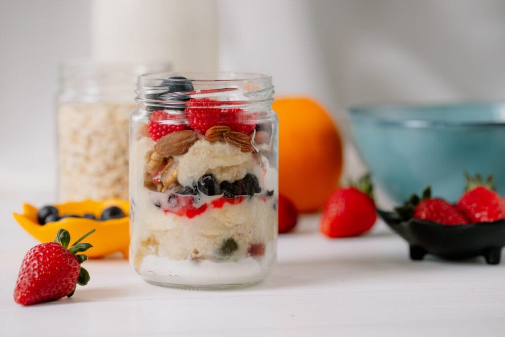 Overnight oats and breakfast meal prep in mason jars with fresh berries and nuts