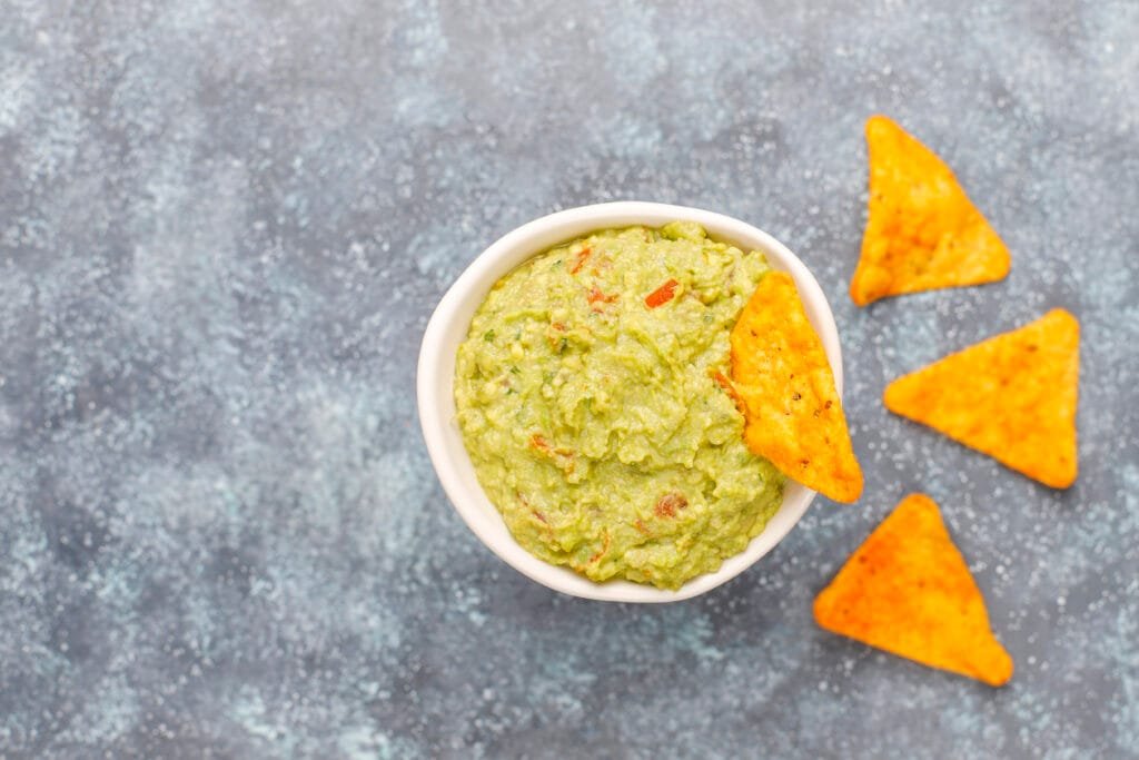 Avocado and lime dressing with nachos set on kitchen top