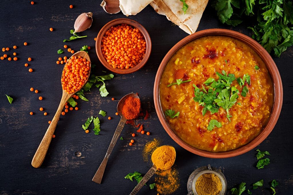 One pot vegetarian meal prep with colorful vegetables and legumes in a large pot